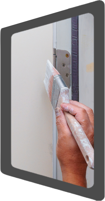 A hand painting a door with a paint brush